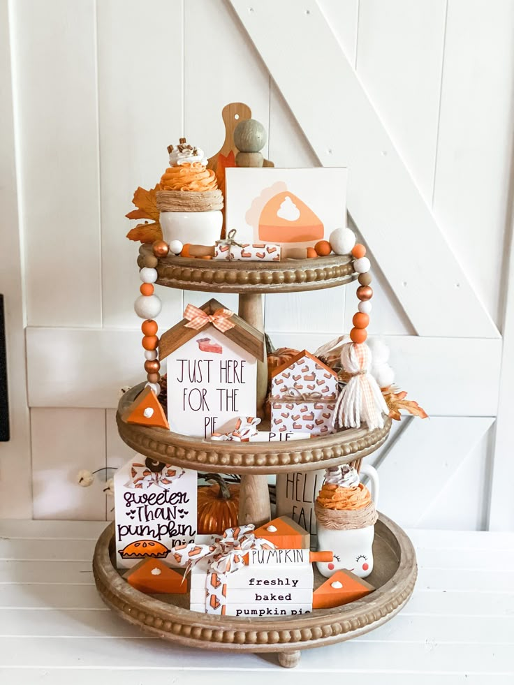 a three tiered tray with cupcakes, cookies and other treats on it