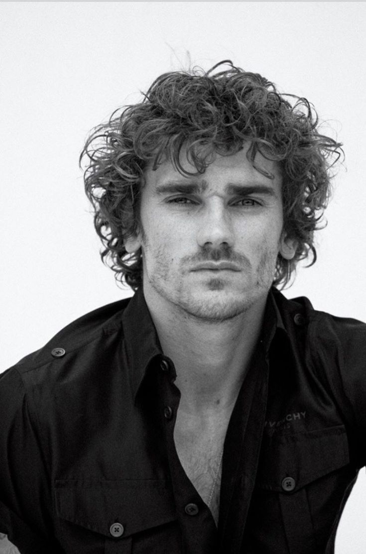 a black and white photo of a man with curly hair