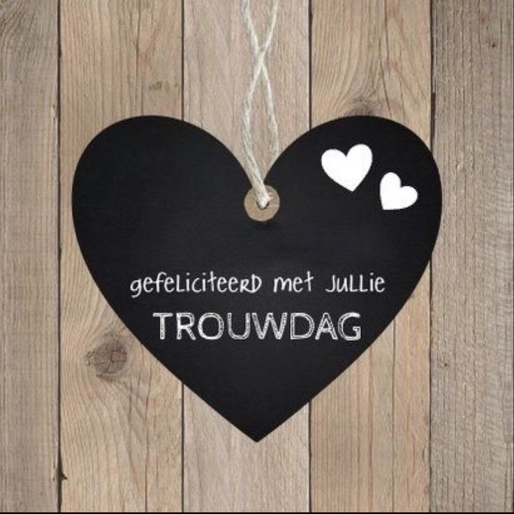 a black heart hanging on a wooden fence with two hearts attached to it and the words,'geeficiated met julia trouwdag '