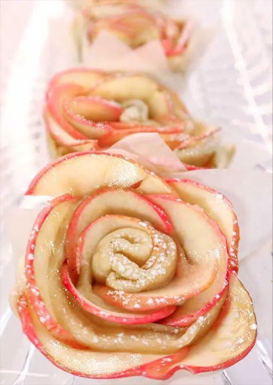 some food is on a clear plate with red and white ribbons in the shape of roses