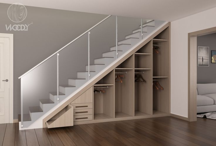 an empty room with stairs leading up to the second floor and a white couch in the background