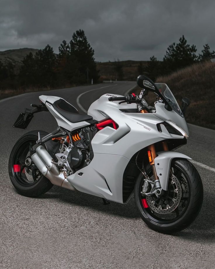 a white motorcycle parked on the side of a road