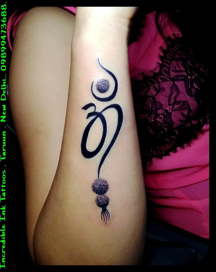 a woman with a tattoo on her arm that has the word om written in cursive writing