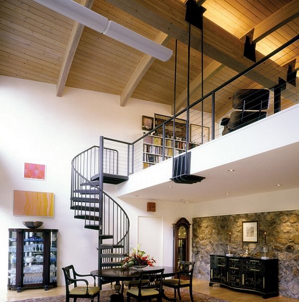 a living room filled with furniture and a spiral stair case next to a fire place