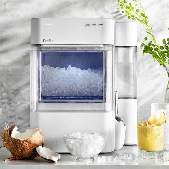 a water dispenser sitting on top of a counter next to some fruit