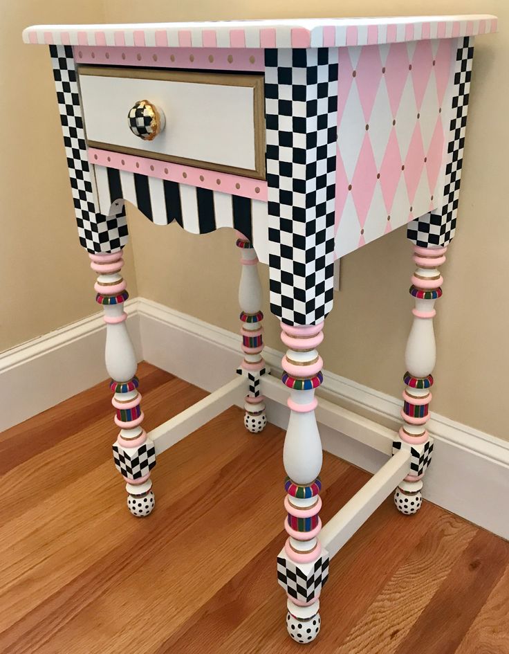 a pink and black checkerboard desk with two drawers on the top, one drawer is