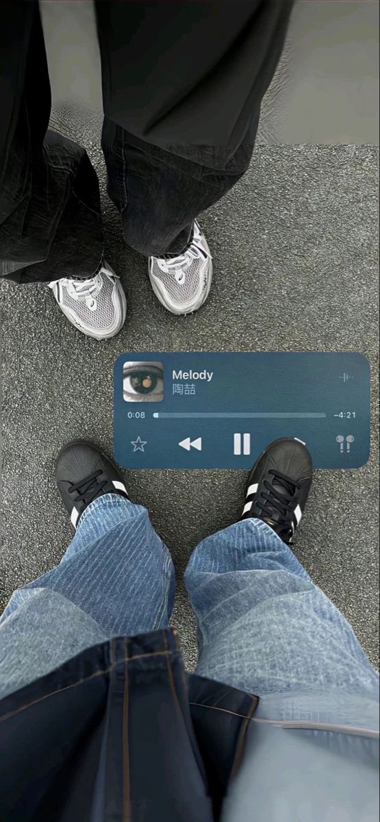 two people standing next to each other with their feet on the ground