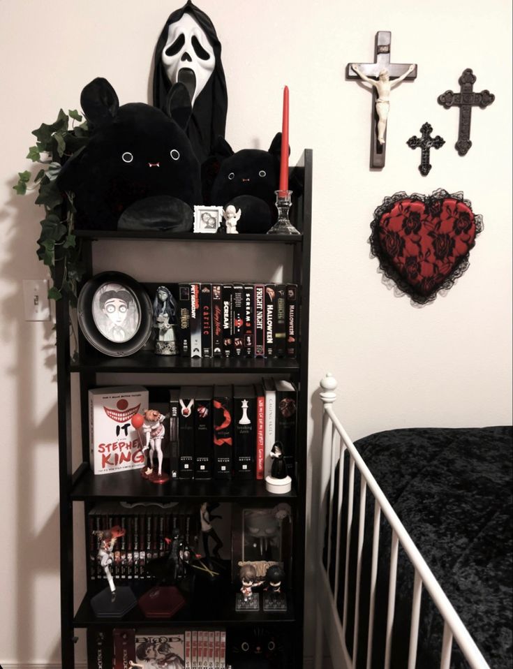 a black book shelf filled with books and other items next to a white crib