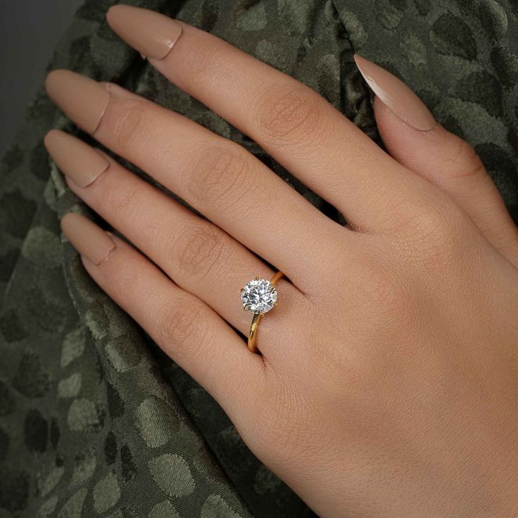 a woman's hand with a diamond ring on it