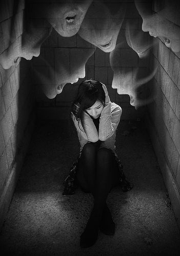 a woman sitting in the middle of a tunnel with her hands on her head