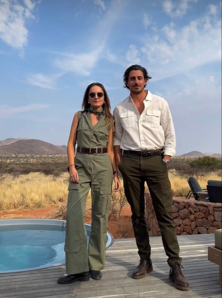 a man and woman standing next to each other on a deck near a swimming pool