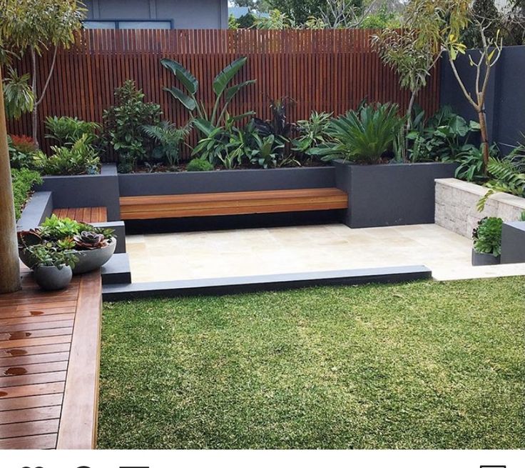 an outdoor garden with wooden benches and plants