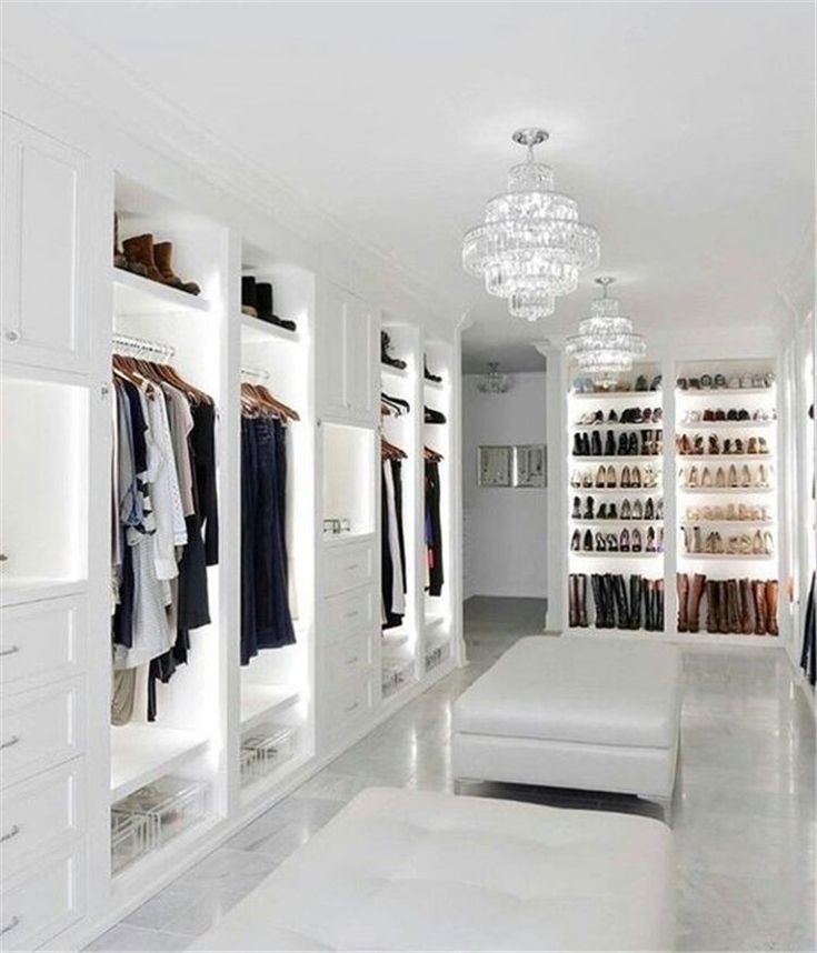 a walk in closet filled with lots of white furniture