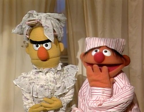 two sesame street characters standing next to each other in front of dr seuss's curtains