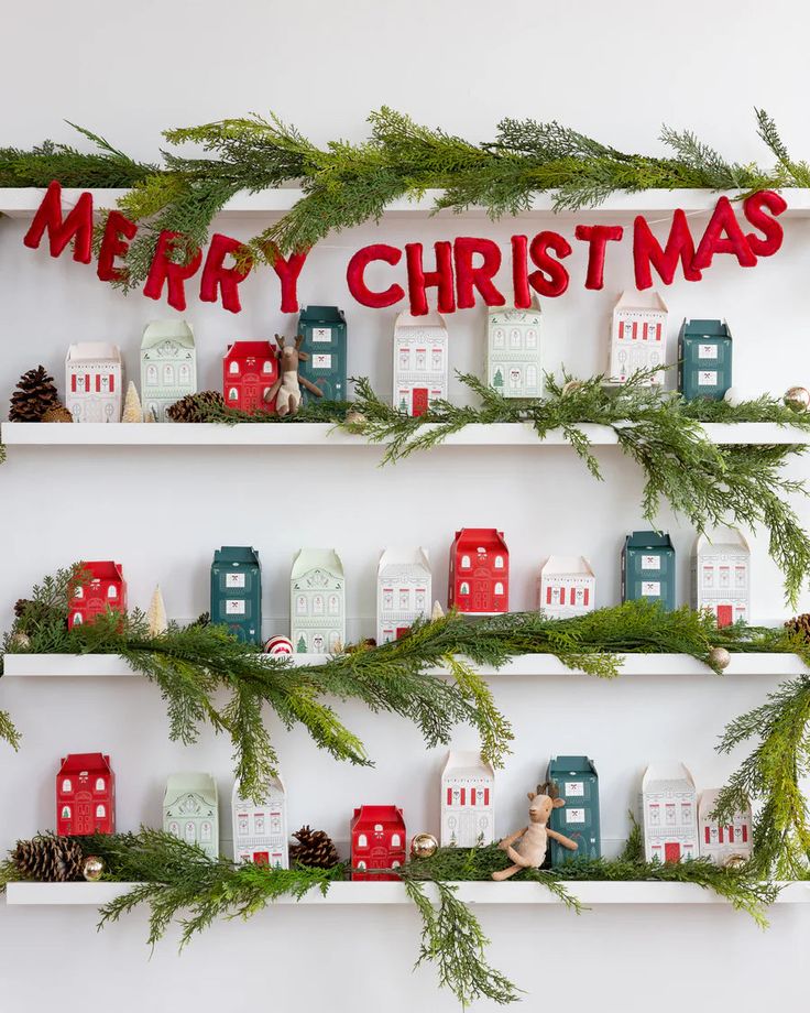 christmas decorations are displayed on shelves in front of a white wall