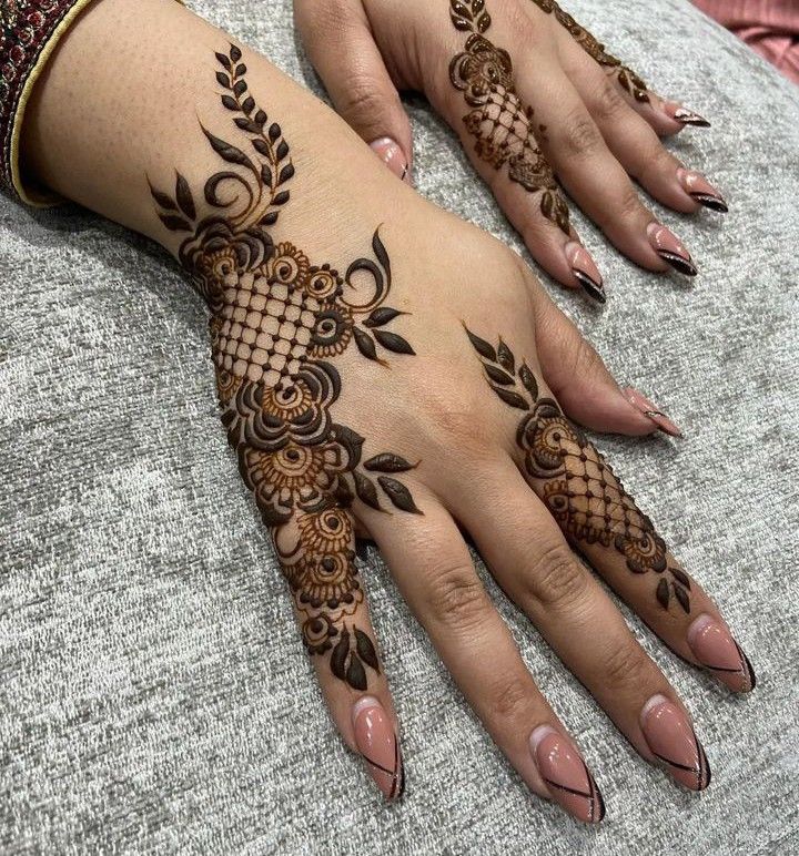 two hands with henna tattoos on them