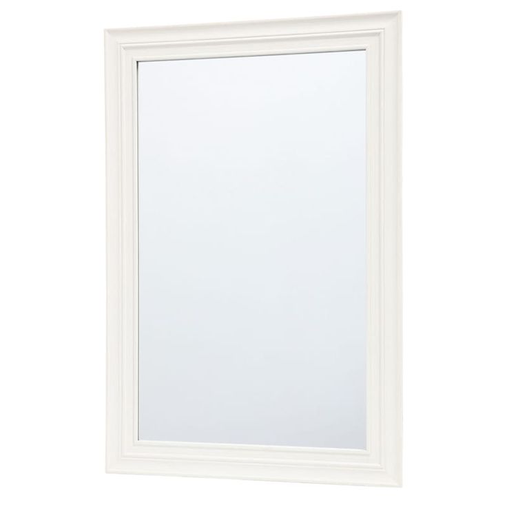 a white framed mirror sitting on top of a wall