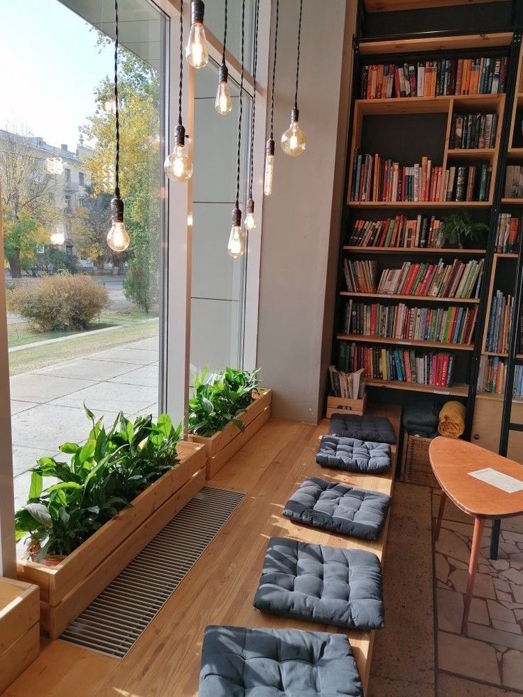 a living room filled with lots of books and plants