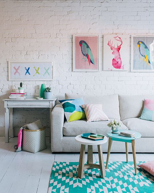 a living room filled with furniture and paintings on the wall above it's coffee table