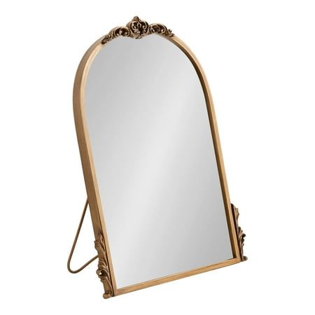 an ornate gold framed mirror sitting on top of a wooden stand with a metal frame