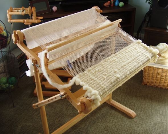 an old weaving machine is sitting on the floor