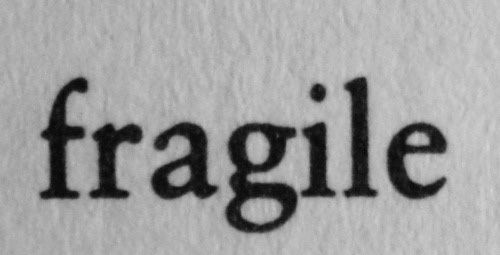 the word fragile written in black ink on white paper