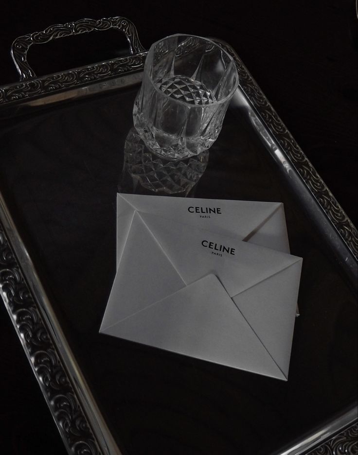 an envelope and glass sitting on a tray