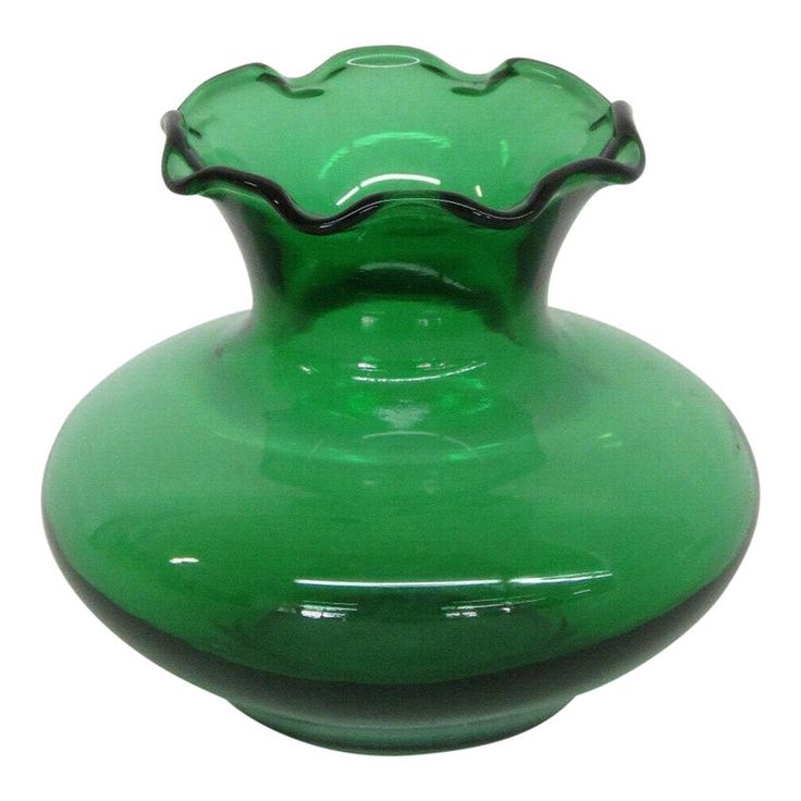 a green glass vase sitting on top of a white table