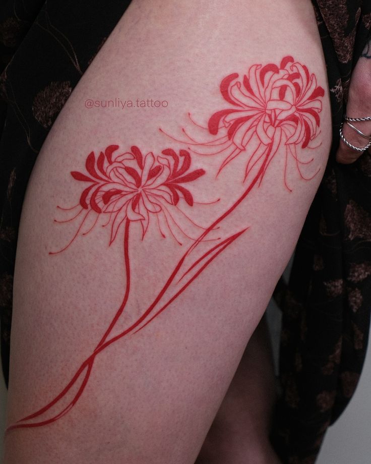 a woman's thigh with red ink on it and flowers drawn on the side