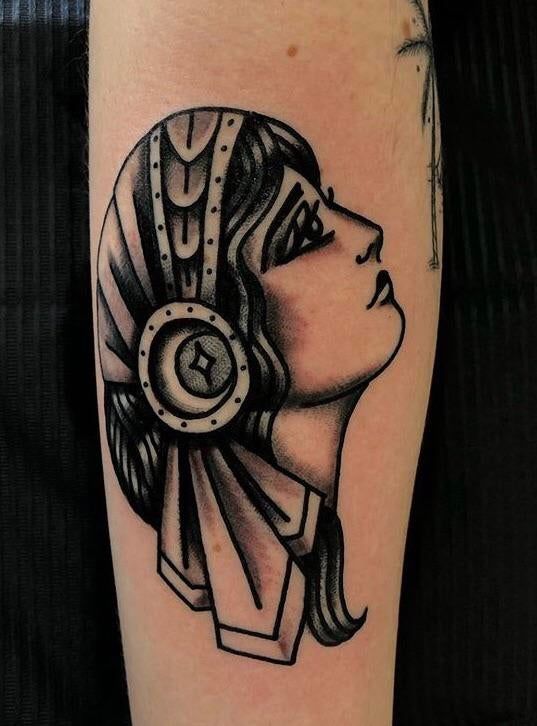 a black and white tattoo with an egyptian woman's head