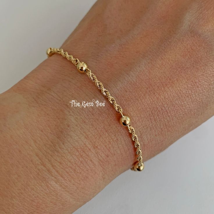 "Thank you for coming in! Genuine 14K SOLID YELLOW GOLD bracelet with 6 ball/bead stations and a spring ring clasp. THEY ARE STAMPED WITH \"585\", but we could not show it clearly in the pictures. Made in Italy! Super cute! You'll get a 7 inch bracelet per winning! We also have 18 inch and 16 inch necklace options in our shop! DIMENSION: 2.2mm rope width, 4mm spheres, 5mm spring ring clasp. WEIGHT: 2 gram MATERIAL: 14K Yellow Gold" Gold Beaded Chain Rosary Bracelet With Round Beads, Gold Rosary Bracelet With Beaded Chain, Gold-plated Chain Bracelet With Gold Beads, Gold Ball Chain Bracelet Gift, Gold Adjustable Ball Chain Bracelet, Gold Ball Chain Bracelet For Everyday, Gold Plated Chain Bracelet With Gold Beads, Gold Bracelet With Beaded Chain And Round Beads, Everyday Gold Ball Chain Beaded Bracelets