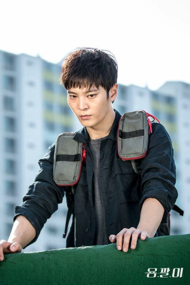 a young man is standing on top of a building