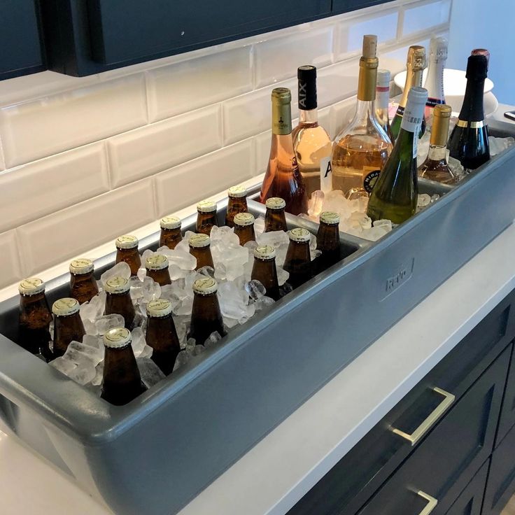 bottles of alcohol are lined up in the sink to be filled with ice cubes