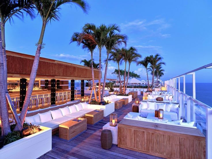 an outdoor hot tub and seating area with palm trees