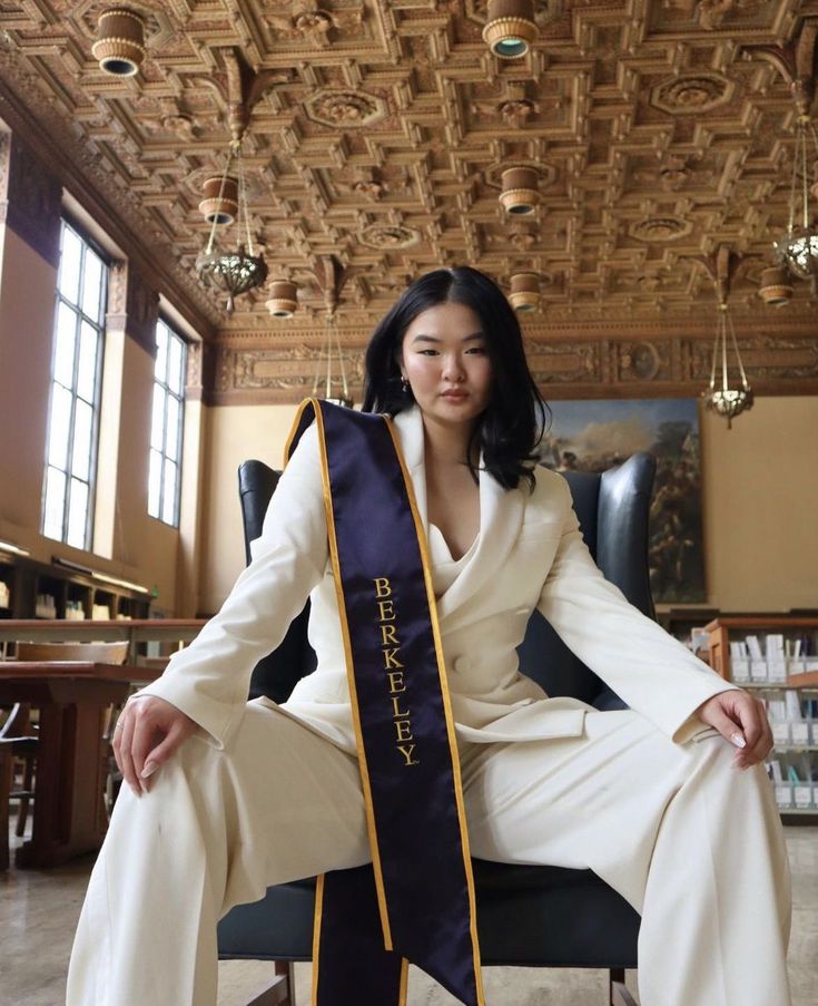 a woman sitting in a chair wearing a sash