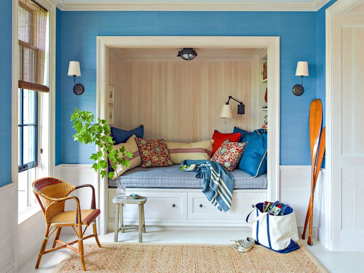 a room that has blue walls and white trim on the wall, with a bench in it