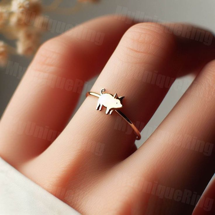 *Free engravings up to 20 characters* 🐷 Step into whimsical elegance with our delightful Gold Women's Pig Ring! 🌸 👑 Make a charming statement with this adorable piece, meticulously crafted with precision and passion. Designed for the modern woman who adores the sweetness and innocence of farm life. 🌿 🌟 Handcrafted from high-quality 10k gold, this dainty ring features a detailed pig design, capturing the playful and endearing nature of these beloved animals. 💫 💖 The pig symbolizes abundance, prosperity, and good fortune, making this ring a perfect accessory for those who seek joy and happiness in the simple pleasures of life. 🌼 🎁 Whether it's a treat for yourself or a cherished gift for someone special, this women's pig ring is sure to bring smiles and become a cherished addition t Cute Gold Ring Jewelry, Adjustable Gold Whimsical Rings, Whimsical Gold Ring Jewelry, Whimsical Adjustable Gold Rings, Animal Design Jewelry Gift, Cute Rose Gold Jewelry For Anniversary, Whimsical Gold Rings For Gift, Cute Gold Rings For Gift, Whimsical Gold Wedding Rings