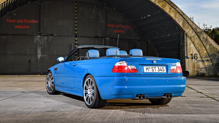 a blue convertible car parked in front of a tunnel