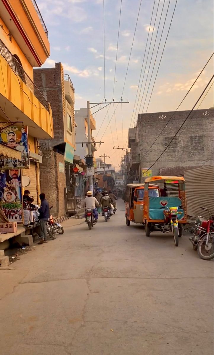 people are riding motorcycles and scooters down the street in front of buildings with shops