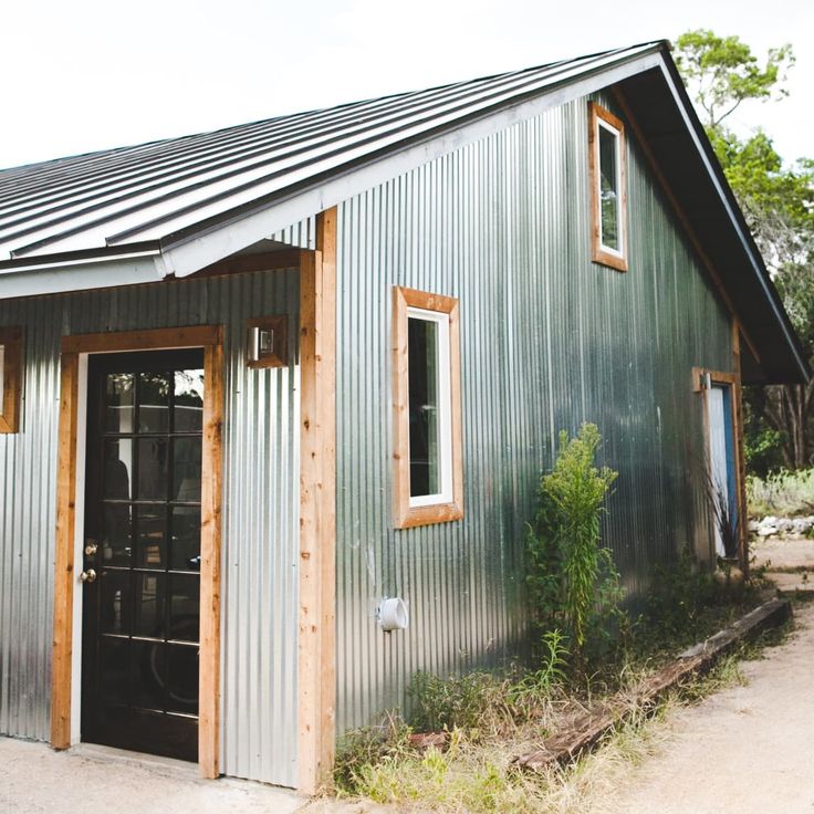 a small metal building with two doors and windows