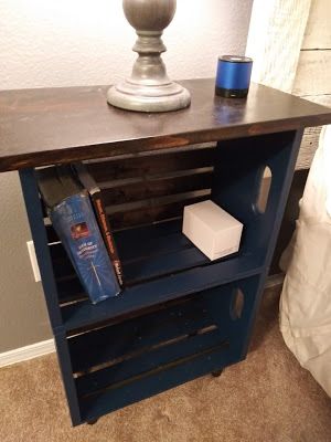 a small wooden table with books on it and a lamp next to it in the corner