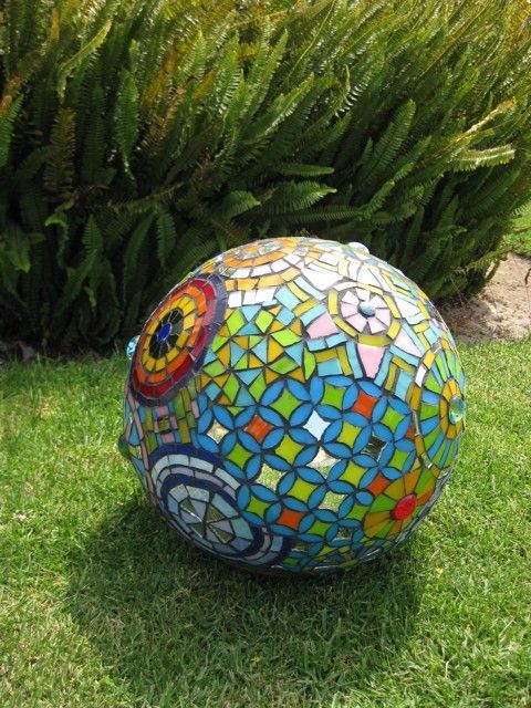 a colorful mosaic ball sitting in the grass