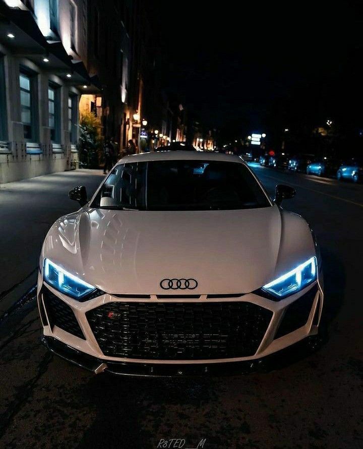 a white car parked on the street at night