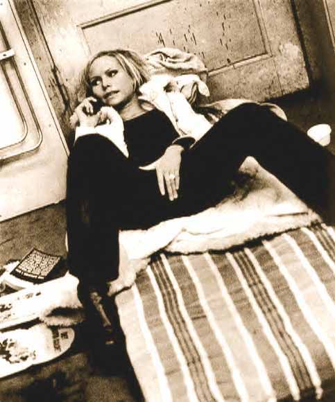 a woman laying on top of a bed next to a train car with the door open