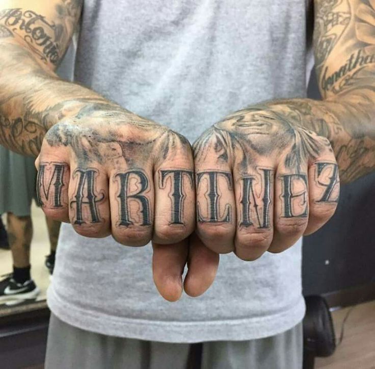 a man with tattoos on his hands is holding up the word