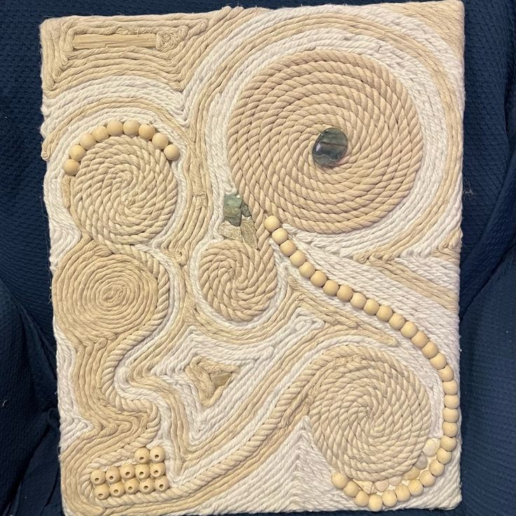 a piece of art that is made out of rope and yarn with circles on it