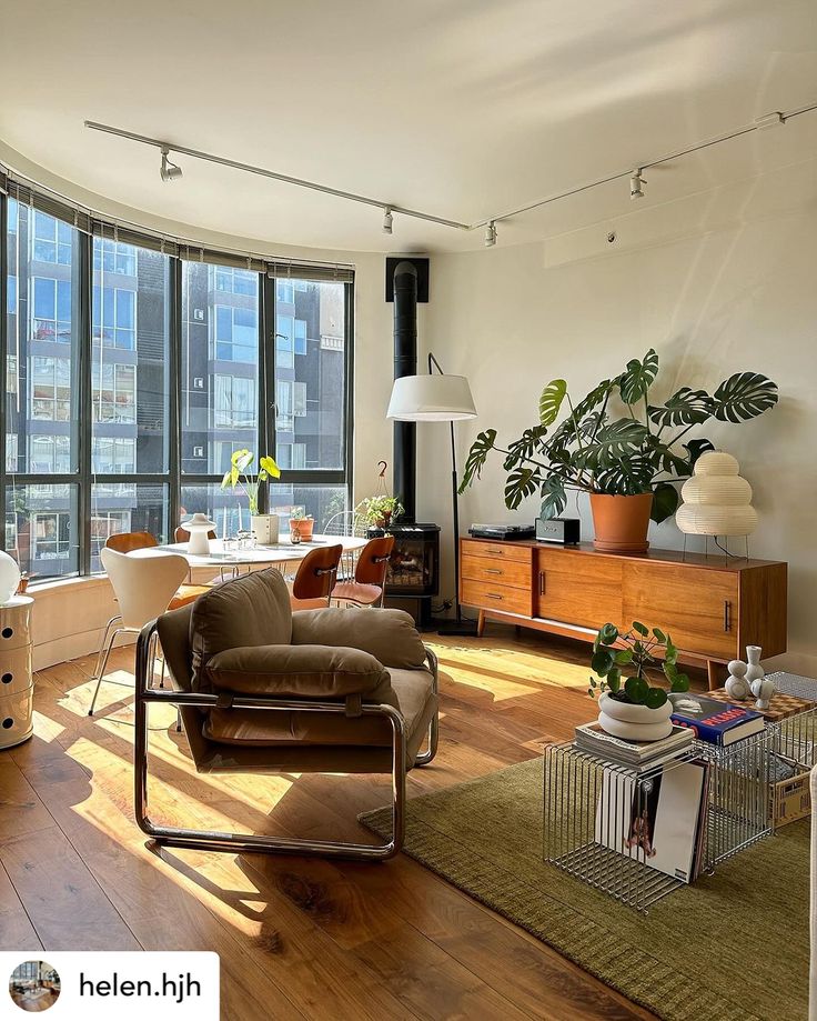 a living room filled with furniture and large windows next to a wooden floored floor