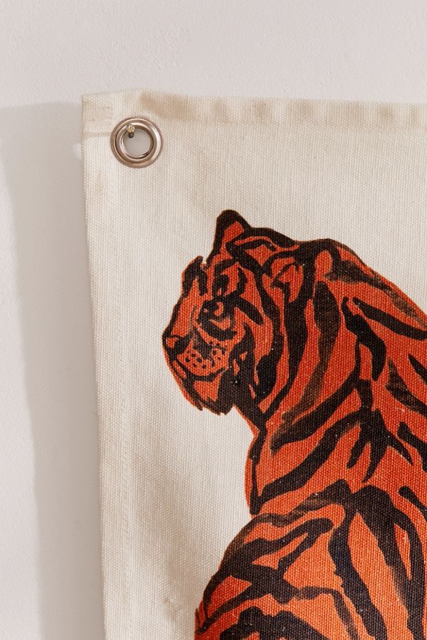 an orange and black tiger is on the side of a white towel hanging from a hook