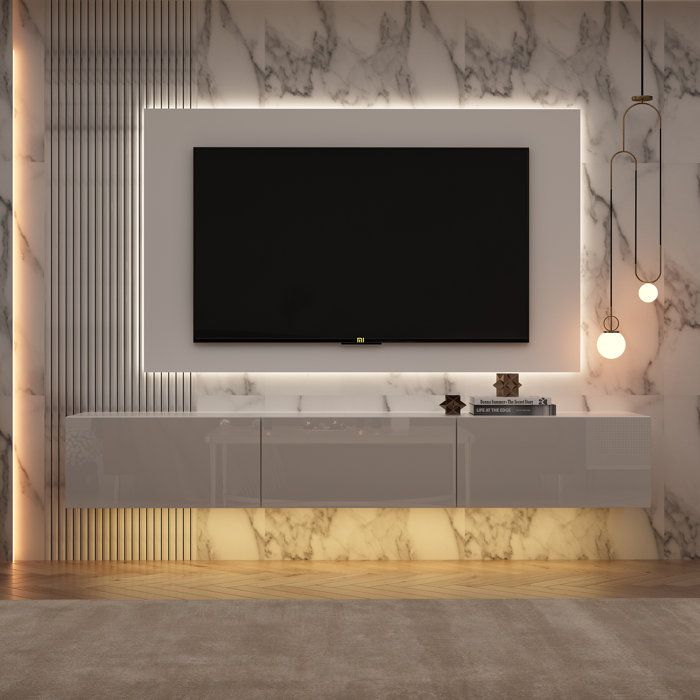 a large television mounted on the wall in a room with marble walls and flooring