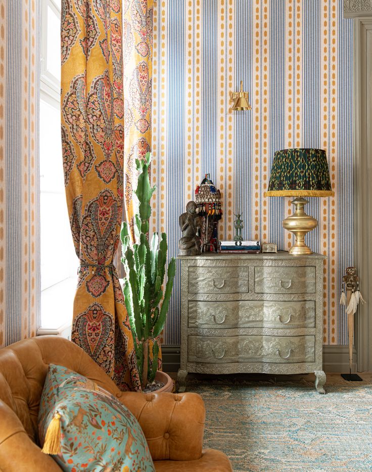 a living room filled with furniture next to a wall covered in striped wallshadves